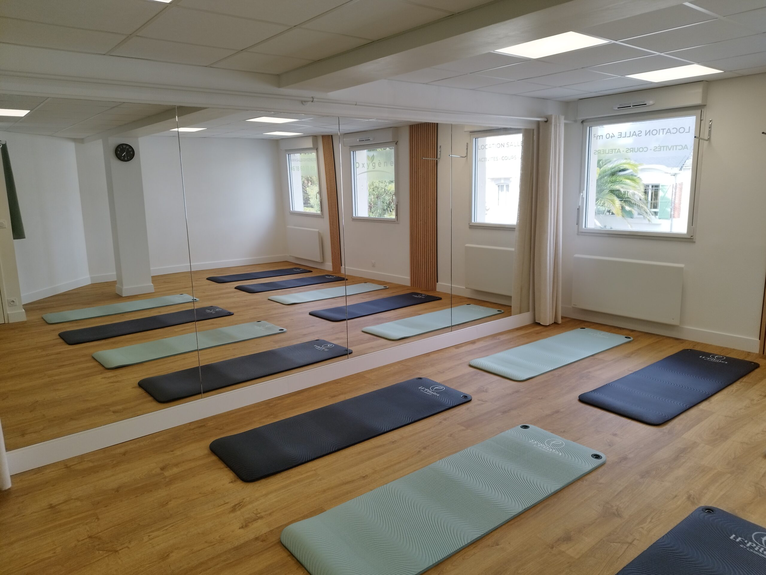Salle Oxygène aménagée pour des cours de yoga à Vannes avec tapis et espace lumineux.
